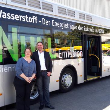 Dr. Christine Pohl und Johannes Klomann vor einem Brennstoffzellenbus der Mainzer Verkehrsgesellschaft